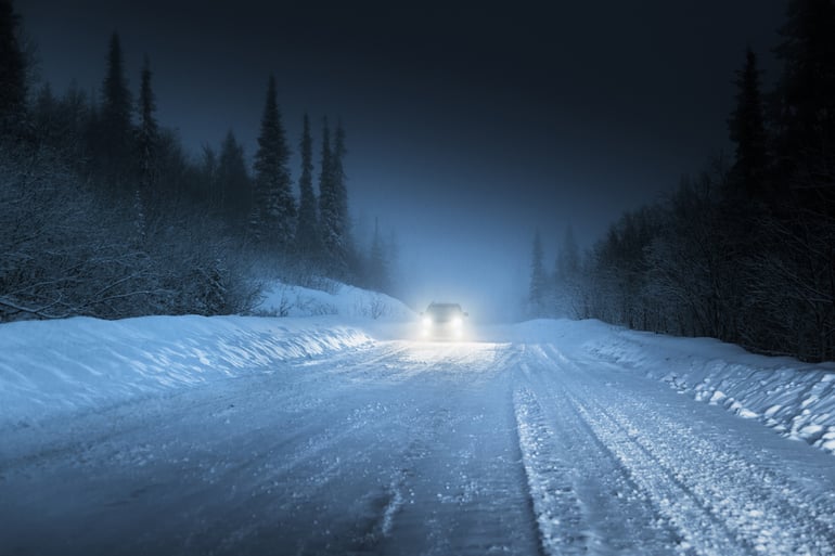 Car lights in winter Russian forest